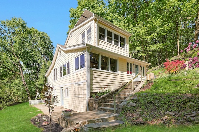 view of front facade with stairs, a patio, and a front yard