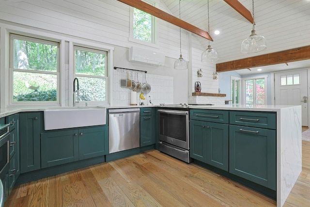 kitchen with green cabinetry, appliances with stainless steel finishes, a sink, a peninsula, and beam ceiling