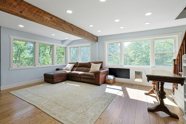 living area featuring baseboards, recessed lighting, plenty of natural light, light wood-type flooring, and beam ceiling