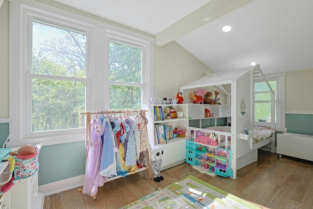playroom with vaulted ceiling, wood finished floors, healthy amount of natural light, and radiator heating unit