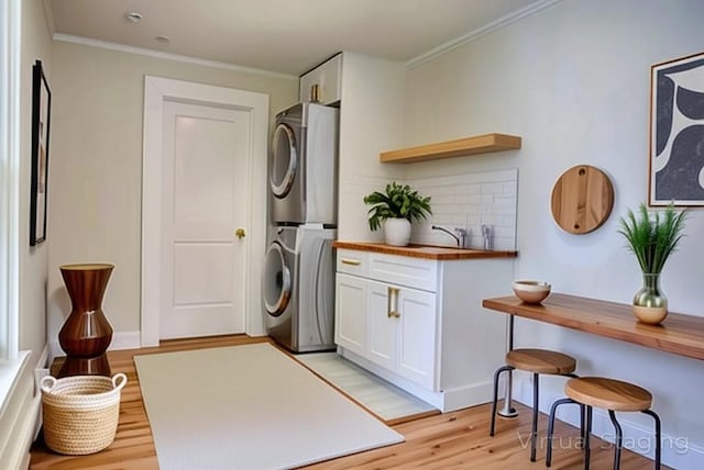 71 Lenox Ave, Congers, NY 10920 - laundry area featuring estacked washer and dryer, light wood finished floors, crown molding, and baseboards