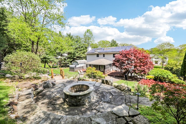 view of patio with a wooden deck, a sunroom, and a fire pit