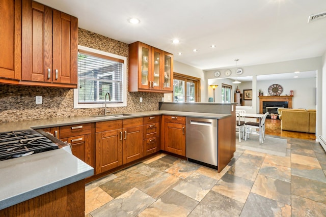kitchen with brown cabinets, a peninsula, a sink, and dishwasher