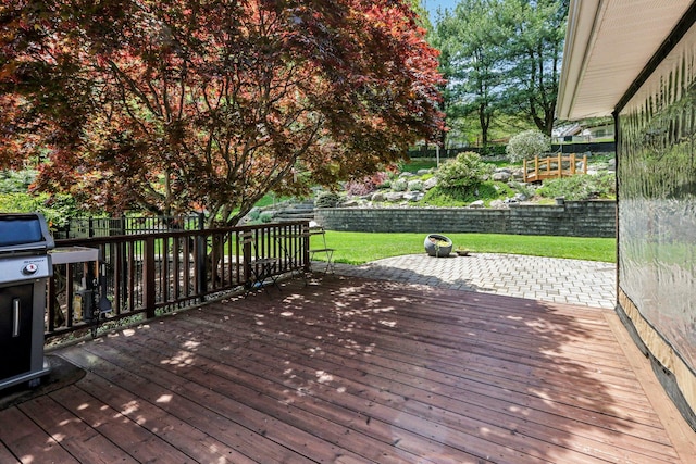wooden deck with a lawn, a fenced backyard, a patio area, and area for grilling