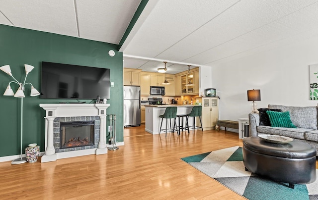 135 Post Ave Unit 5N, Westbury, NY 11590 - living room with a textured ceiling, light wood finished floors, and a tile fireplace