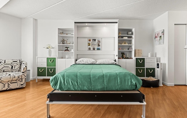 135 Post Ave Unit 5N, Westbury, NY 11590 - bedroom with baseboards, a textured ceiling, and wood finished floors