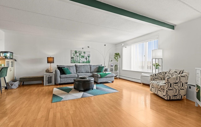 135 Post Ave Unit 5N, Westbury, NY 11590 - living area featuring a textured ceiling, beamed ceiling, baseboard heating, and wood finished floors