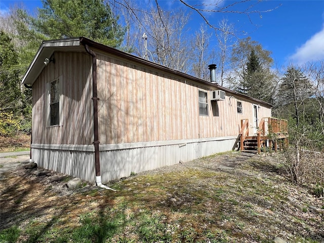 view of home's exterior with a wooden deck and a wall unit AC