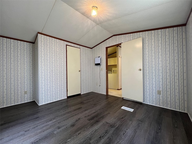 interior space with lofted ceiling, visible vents, wallpapered walls, and wood finished floors