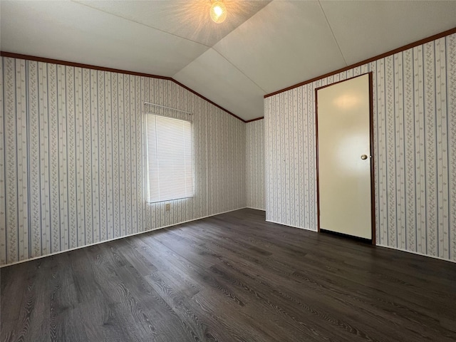 bonus room featuring lofted ceiling, wallpapered walls, and dark wood finished floors
