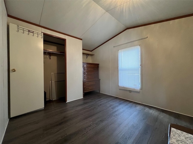 unfurnished bedroom featuring lofted ceiling, ornamental molding, a closet, and dark wood-type flooring