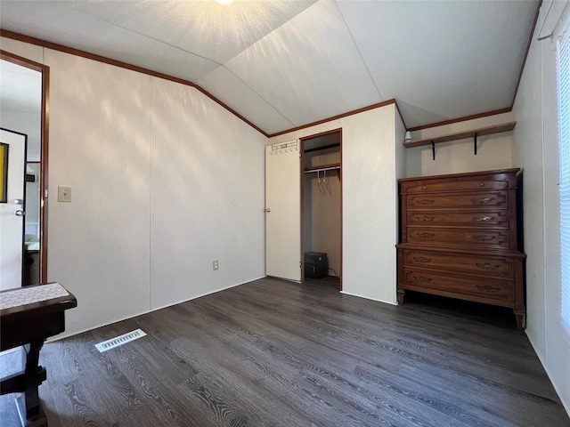 unfurnished bedroom featuring lofted ceiling, a closet, visible vents, and dark wood finished floors