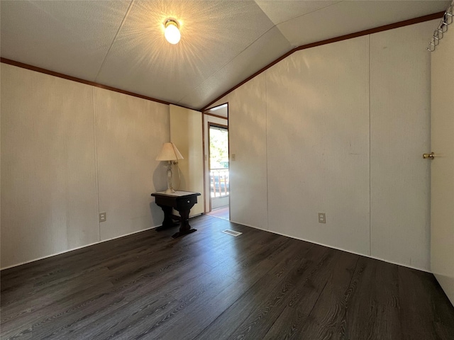 unfurnished room featuring lofted ceiling, visible vents, and wood finished floors