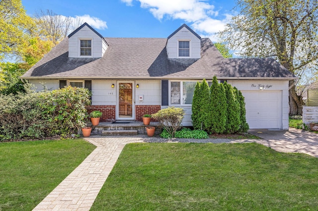 cape cod-style house with a shingled roof, an attached garage, a front lawn, brick siding, and driveway