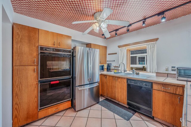 kitchen featuring brown cabinets, ceiling fan, a sink, rail lighting, and black appliances