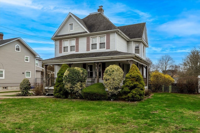victorian house featuring a shingled roof, covered porch, a chimney, and a front lawn