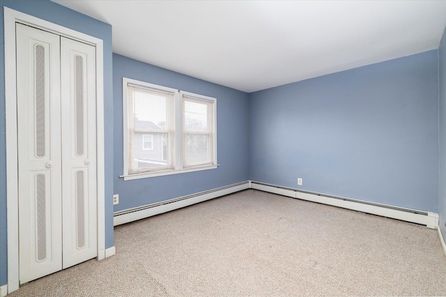 unfurnished bedroom with a closet, carpet, baseboards, and baseboard heating