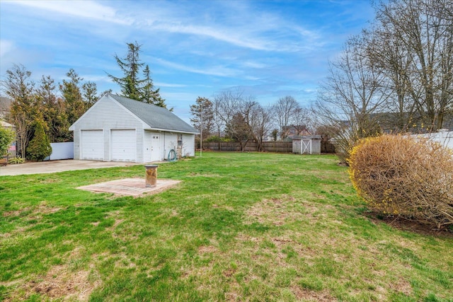 view of yard with an outdoor structure, a fenced backyard, and a garage