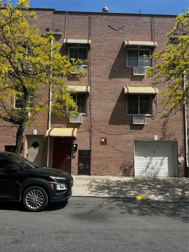 view of building exterior featuring an attached garage and driveway
