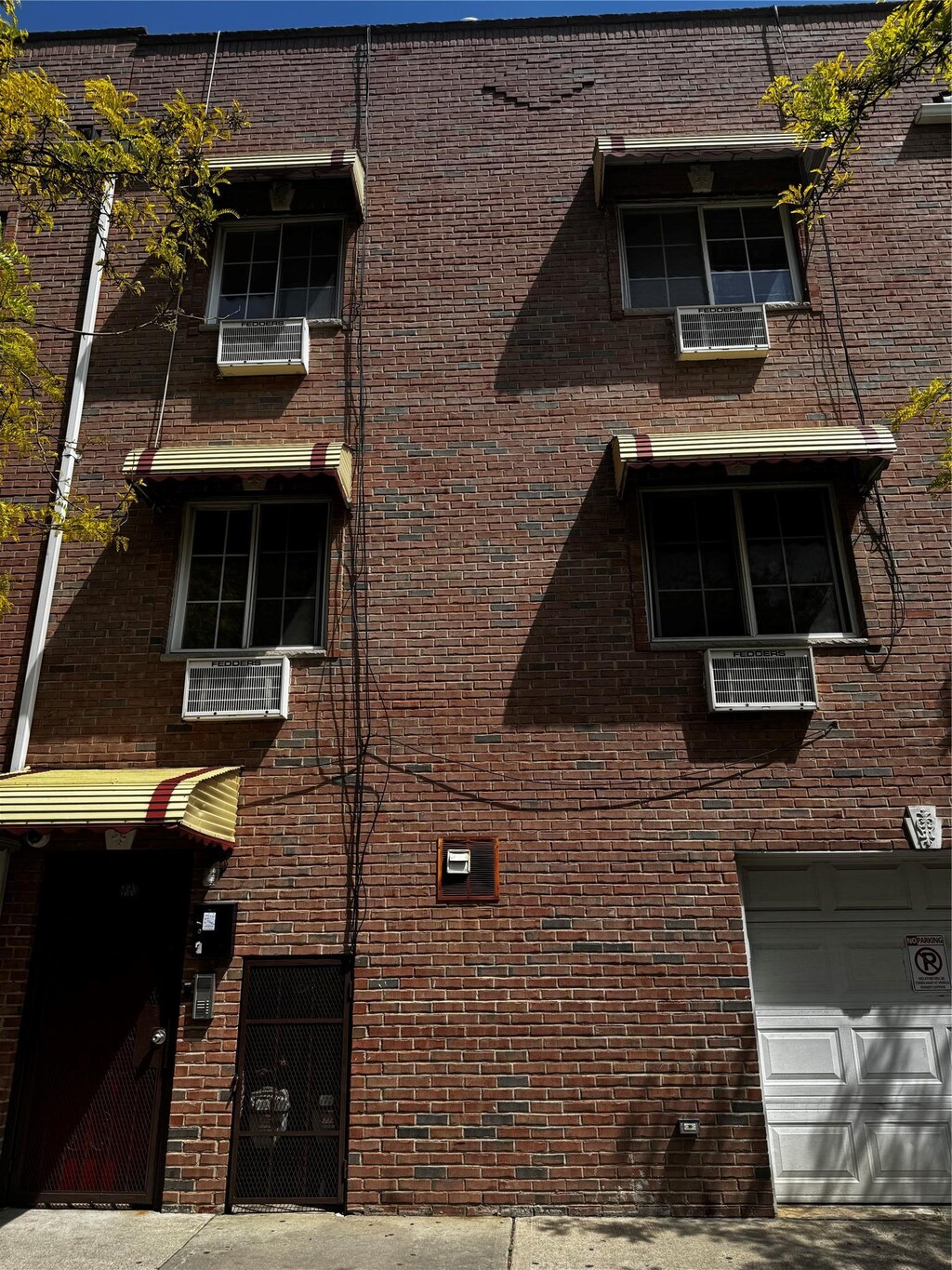 view of side of home featuring an attached garage and brick siding