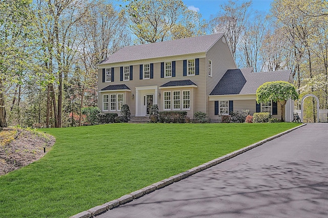 colonial home featuring a front lawn