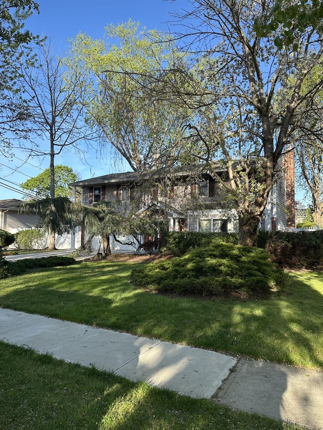view of front facade featuring a chimney and a front lawn