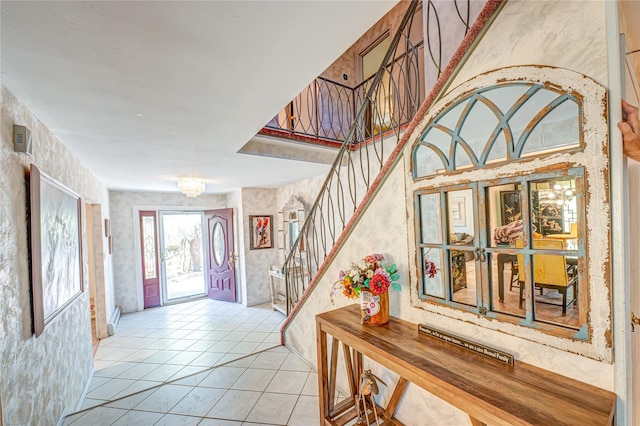 foyer with stairs, light tile patterned flooring, and wallpapered walls