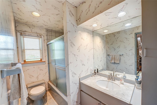 full bathroom featuring toilet, wallpapered walls, and vanity