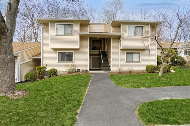 view of front of home featuring stairs and a front lawn