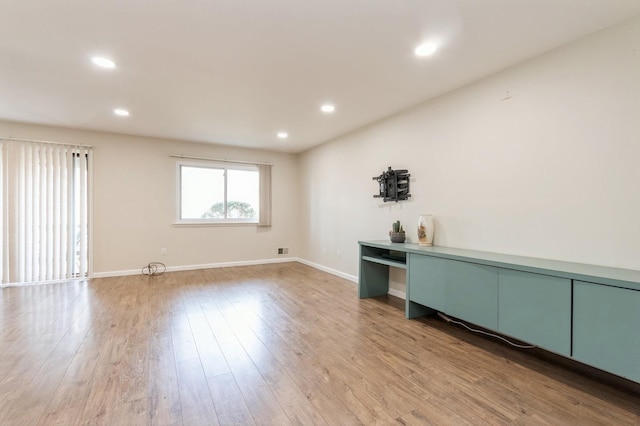 spare room with recessed lighting, light wood finished floors, and baseboards