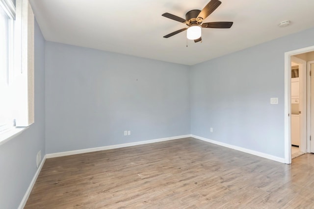 unfurnished room featuring baseboards, ceiling fan, wood finished floors, and visible vents