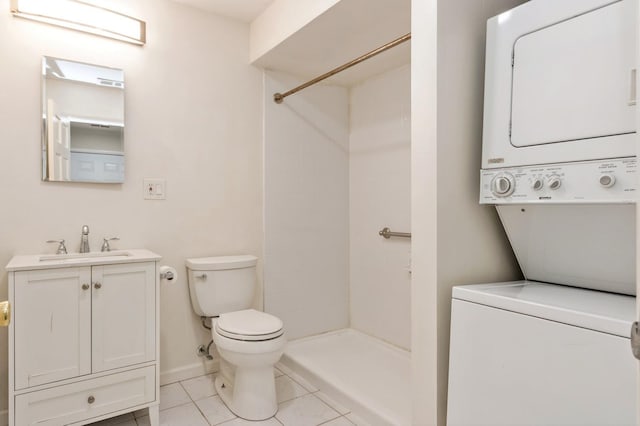 bathroom featuring a shower, stacked washer / drying machine, toilet, and vanity