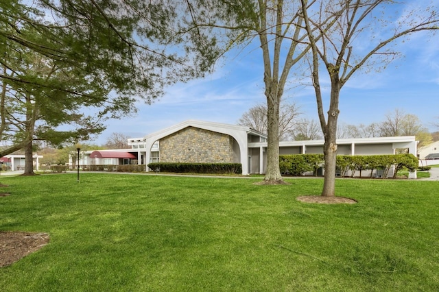 view of front of home with stone siding and a front yard