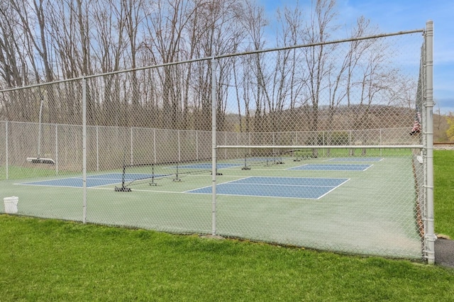 view of sport court with a yard and fence