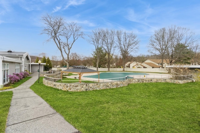 view of home's community with a lawn, a swimming pool, and fence