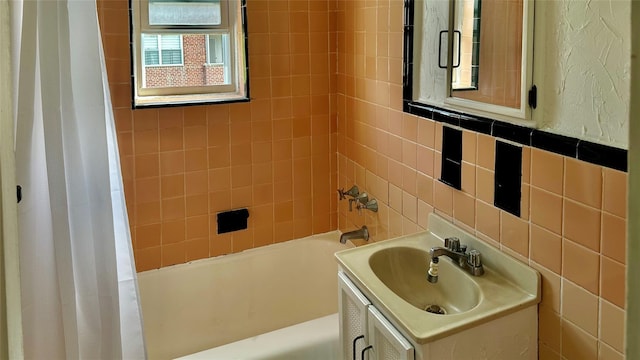 bathroom with vanity, shower / bath combination with curtain, and tile walls