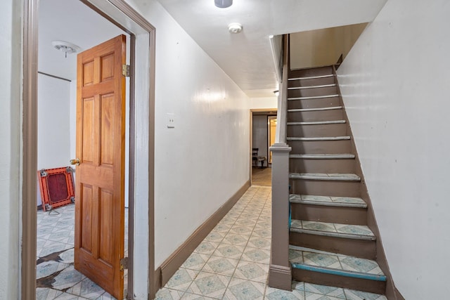 stairway featuring baseboards and tile patterned flooring