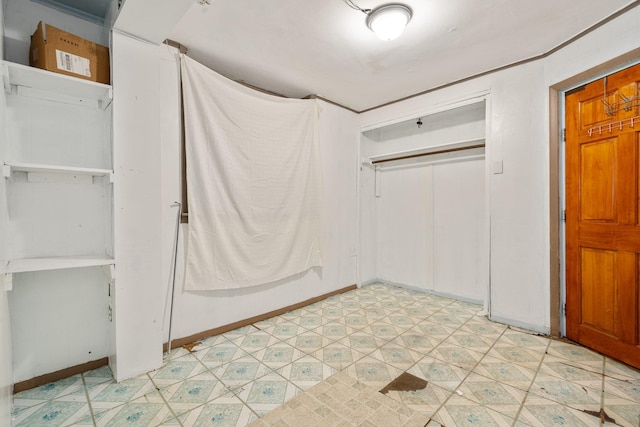 unfurnished bedroom with a closet, baseboards, and light floors