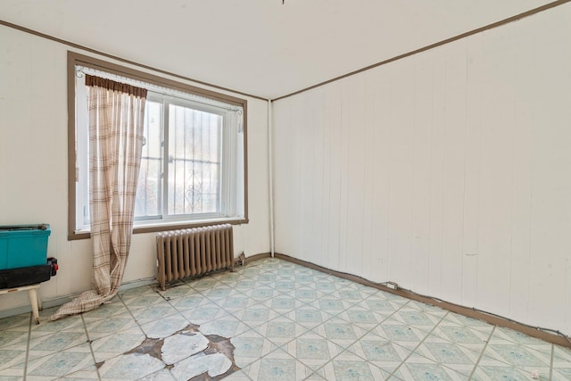 spare room featuring light floors and radiator heating unit