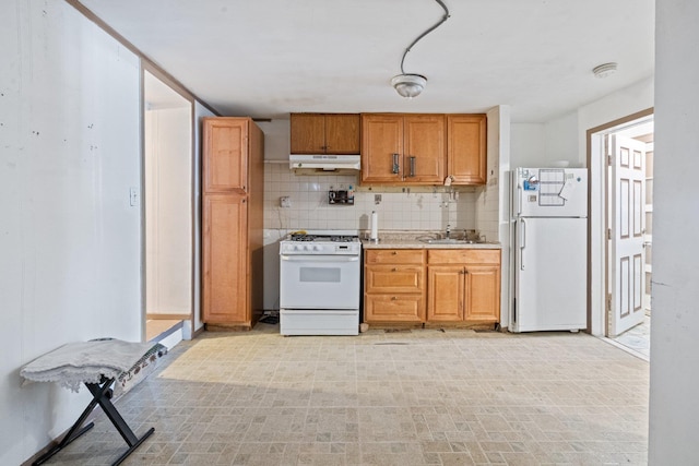 kitchen with a sink, white appliances, brown cabinetry, tasteful backsplash, and under cabinet range hood
