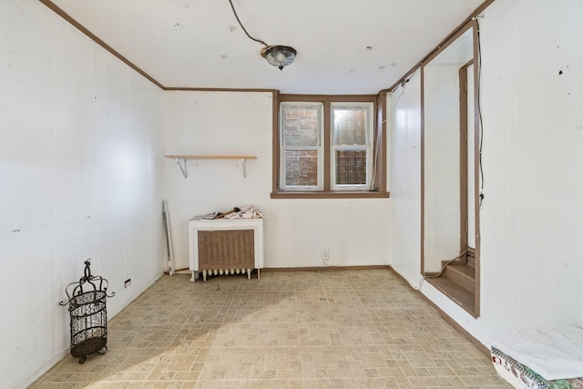 unfurnished room with radiator heating unit and stairway