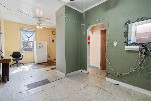 interior space featuring baseboards, arched walkways, and ornamental molding