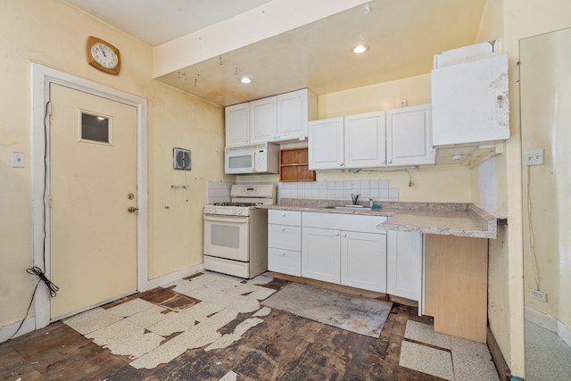 kitchen with a sink, light countertops, white cabinets, baseboards, and white appliances
