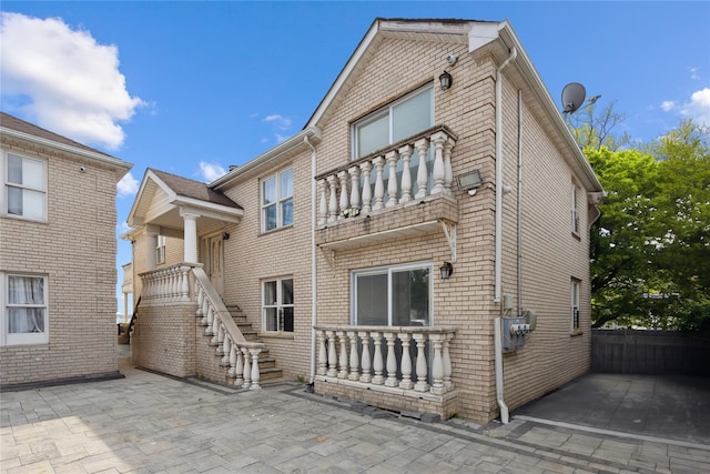rear view of house with a patio area and a balcony