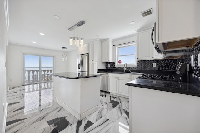 kitchen featuring visible vents, dark countertops, a sink, appliances with stainless steel finishes, and backsplash
