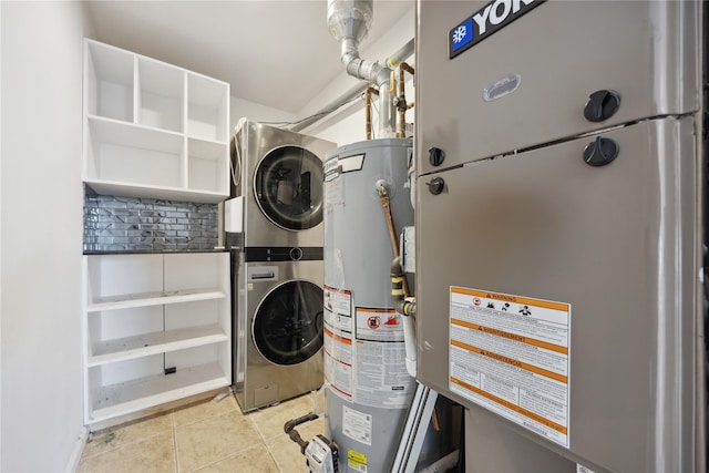 laundry area featuring water heater, light tile patterned floors, laundry area, and stacked washer / drying machine