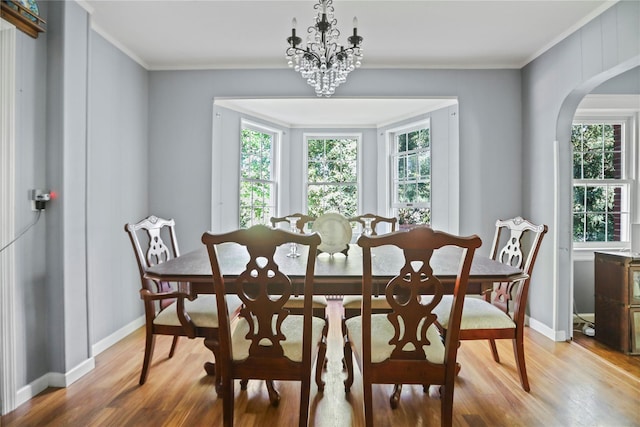 8 Rose Ct, Northport, NY 11768 - dining area featuring a healthy amount of sunlight, arched walkways, ornamental molding, and light wood-style flooring