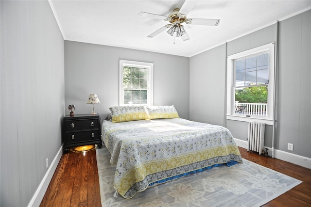 8 Rose Ct, Northport, NY 11768 - bedroom with crown molding, radiator, a ceiling fan, baseboards, and wood finished floors