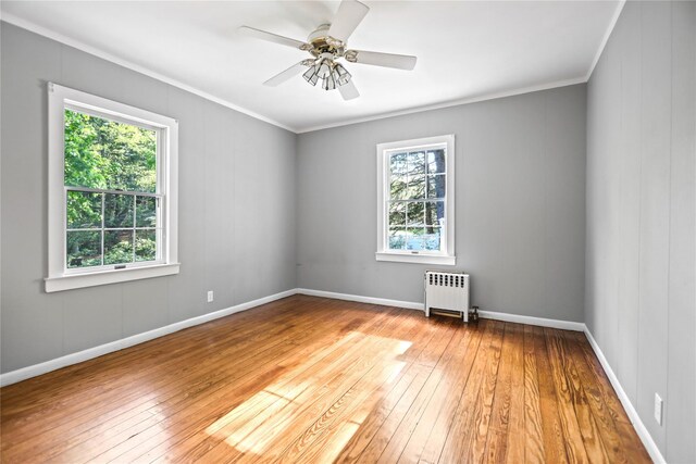 8 Rose Ct, Northport, NY 11768 - unfurnished room with wood-type flooring, ornamental molding, plenty of natural light, and radiator heating unit