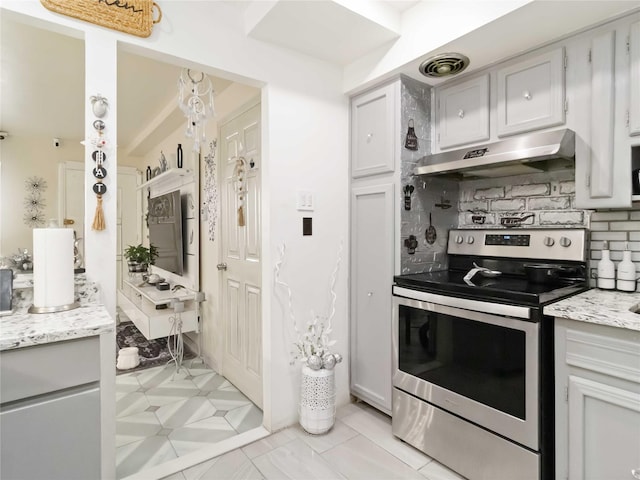 81-56 102nd Rd, Ozone Park, NY 11416 - kitchen with electric range, light stone countertops, backsplash, under cabinet range hood, and visible vents